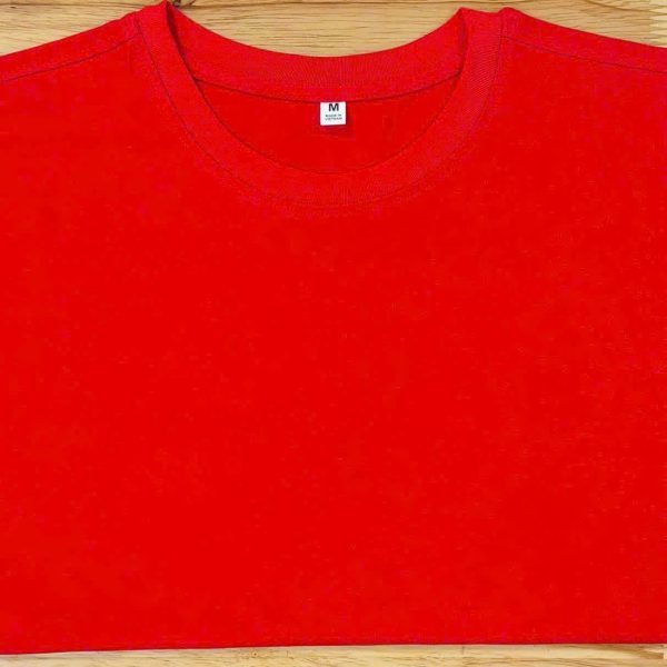 Áo cổ tròn cotton 4 chiều màu đỏ tươi, gấp phẳng trên nền gỗ