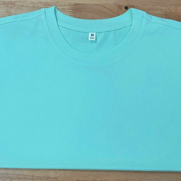 Áo cổ tròn cotton 4 chiều màu xanh ngọc, gấp phẳng trên nền gỗ